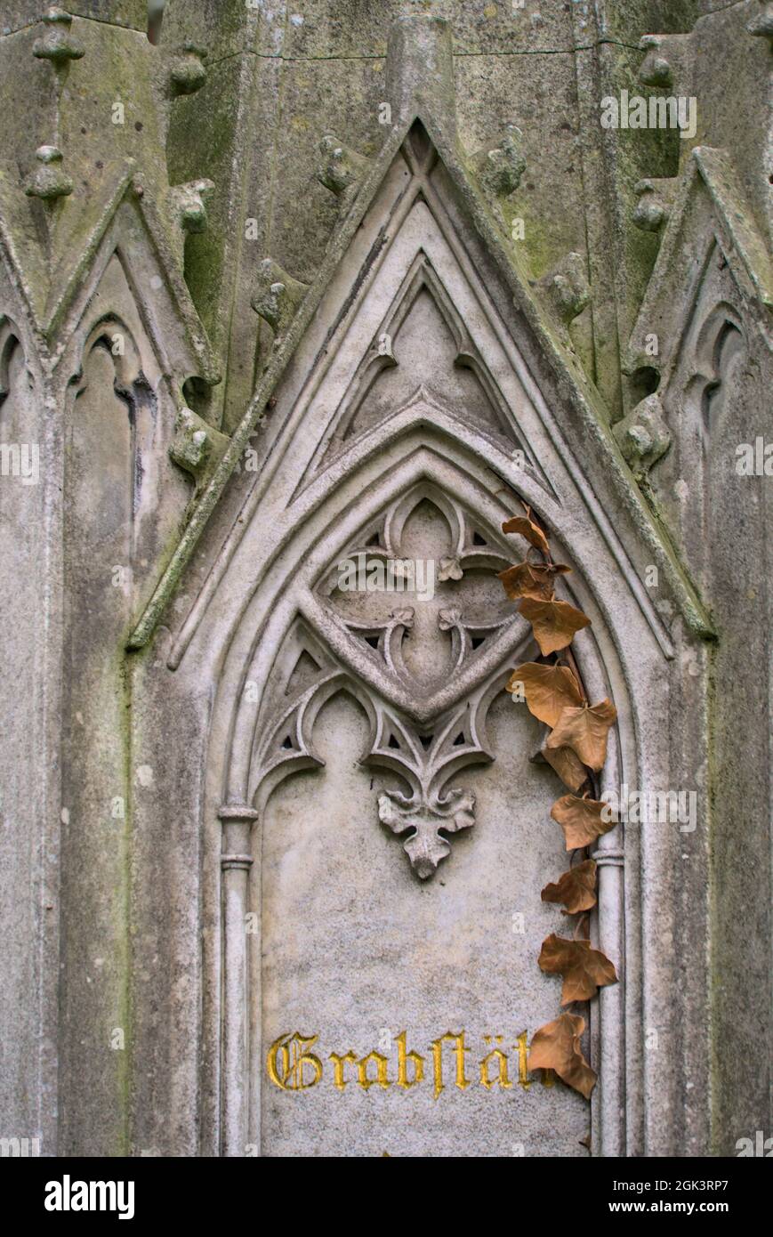 Vertical shot of a part of a weathered ornamental stone sculpture in a cemetery Stock Photo