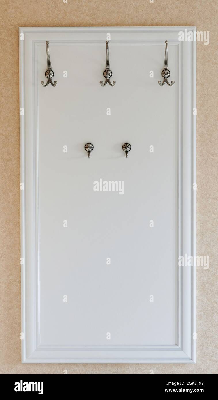 Hangers on entrance wall on white wooden board Stock Photo