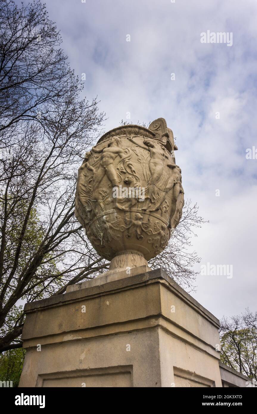Vase-shaped stone sculpture on a column in a park Stock Photo