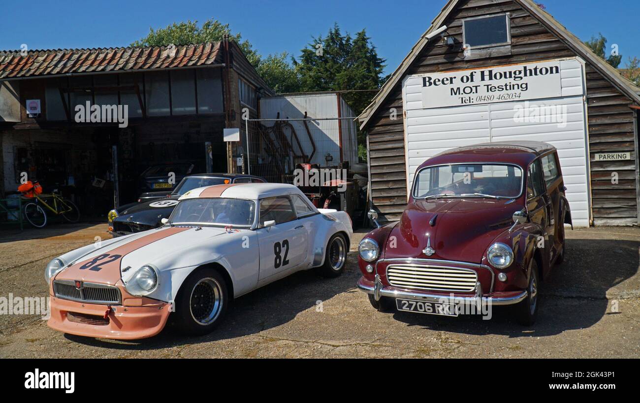 Vintage cars parked outside repair shop, MG and Morris Traveller. Stock Photo