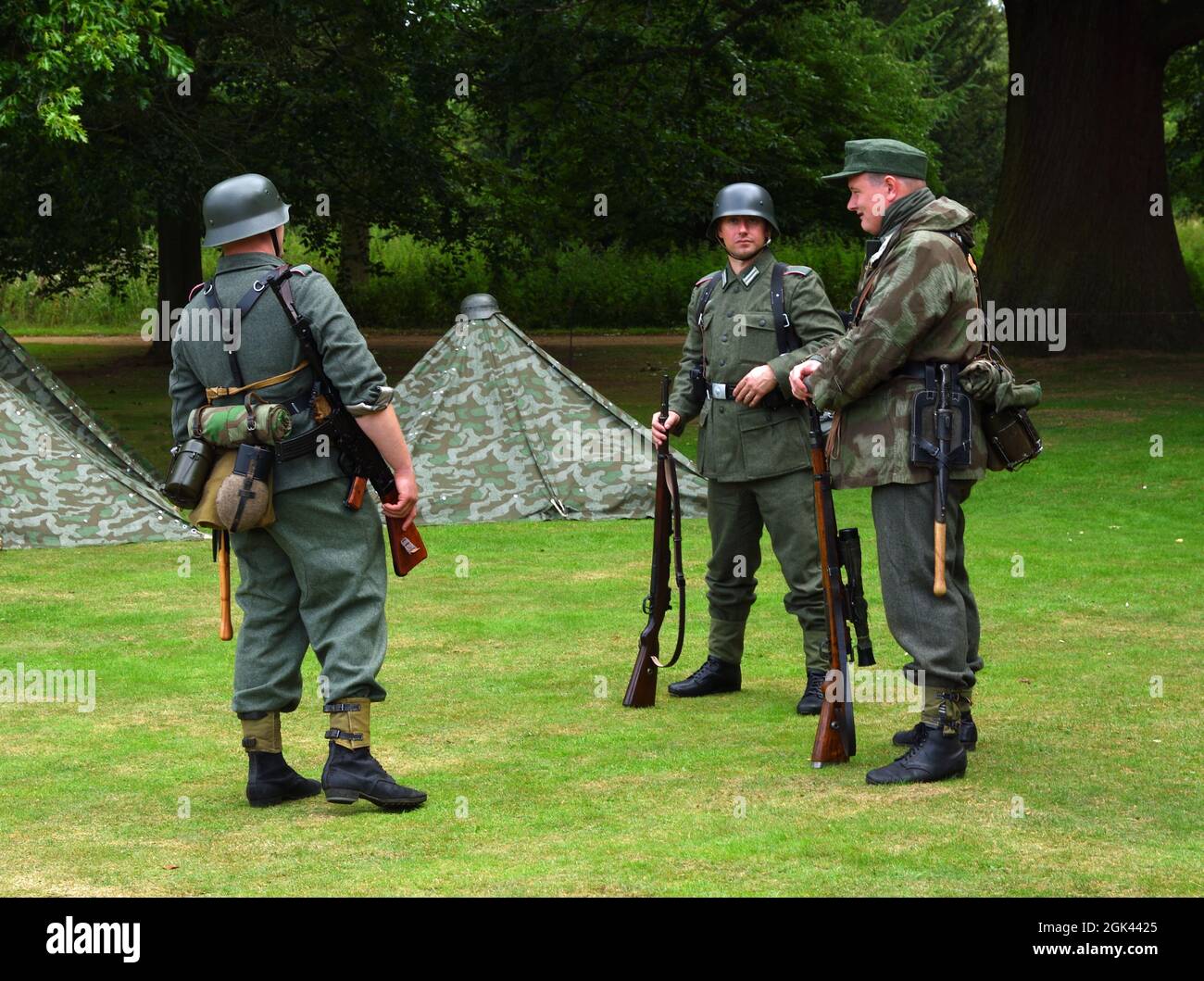 Three Infantryman from reenactment group in WW2  German uniforms with guns. Stock Photo