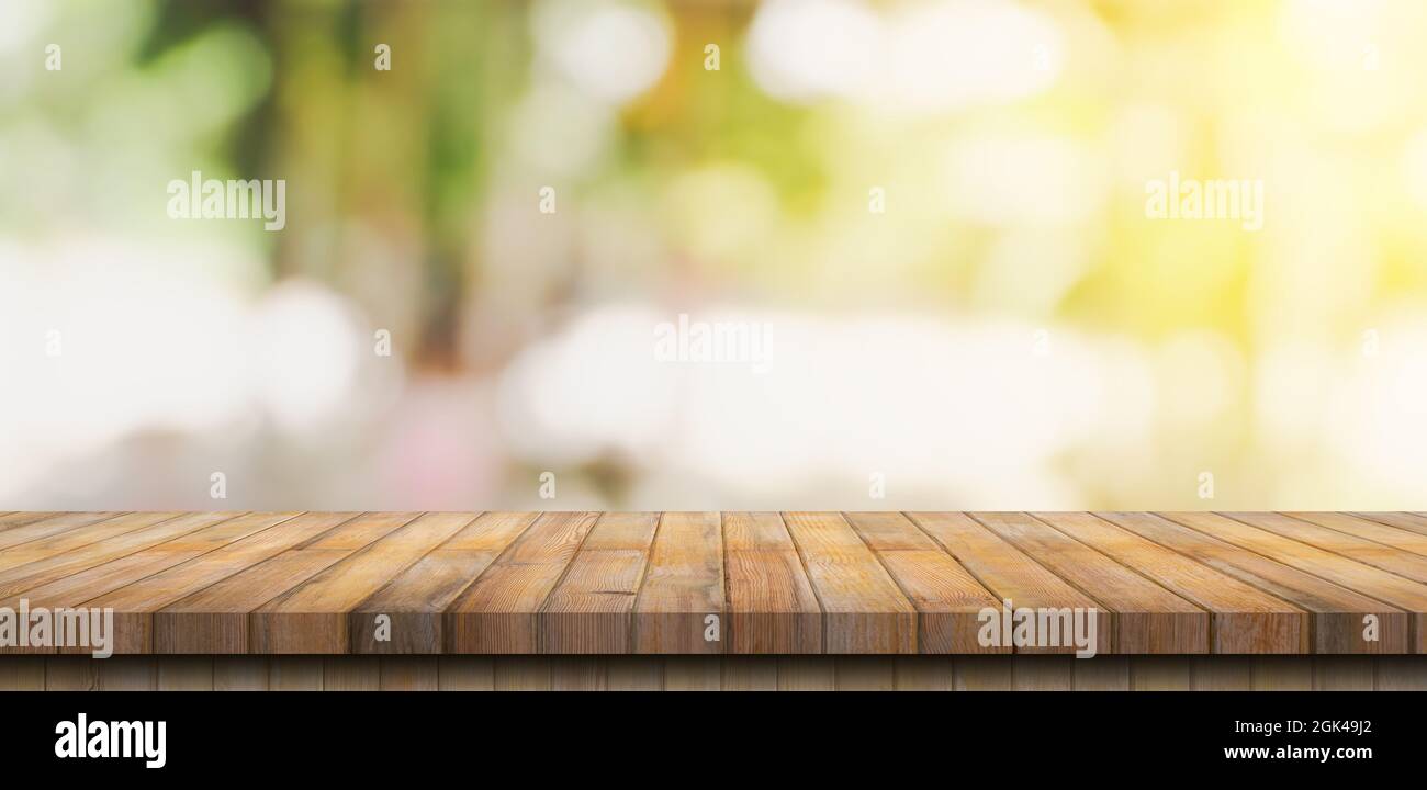 Empty wood table and blurred light table in coffee shop and cafe with bokeh background. product display template. Stock Photo
