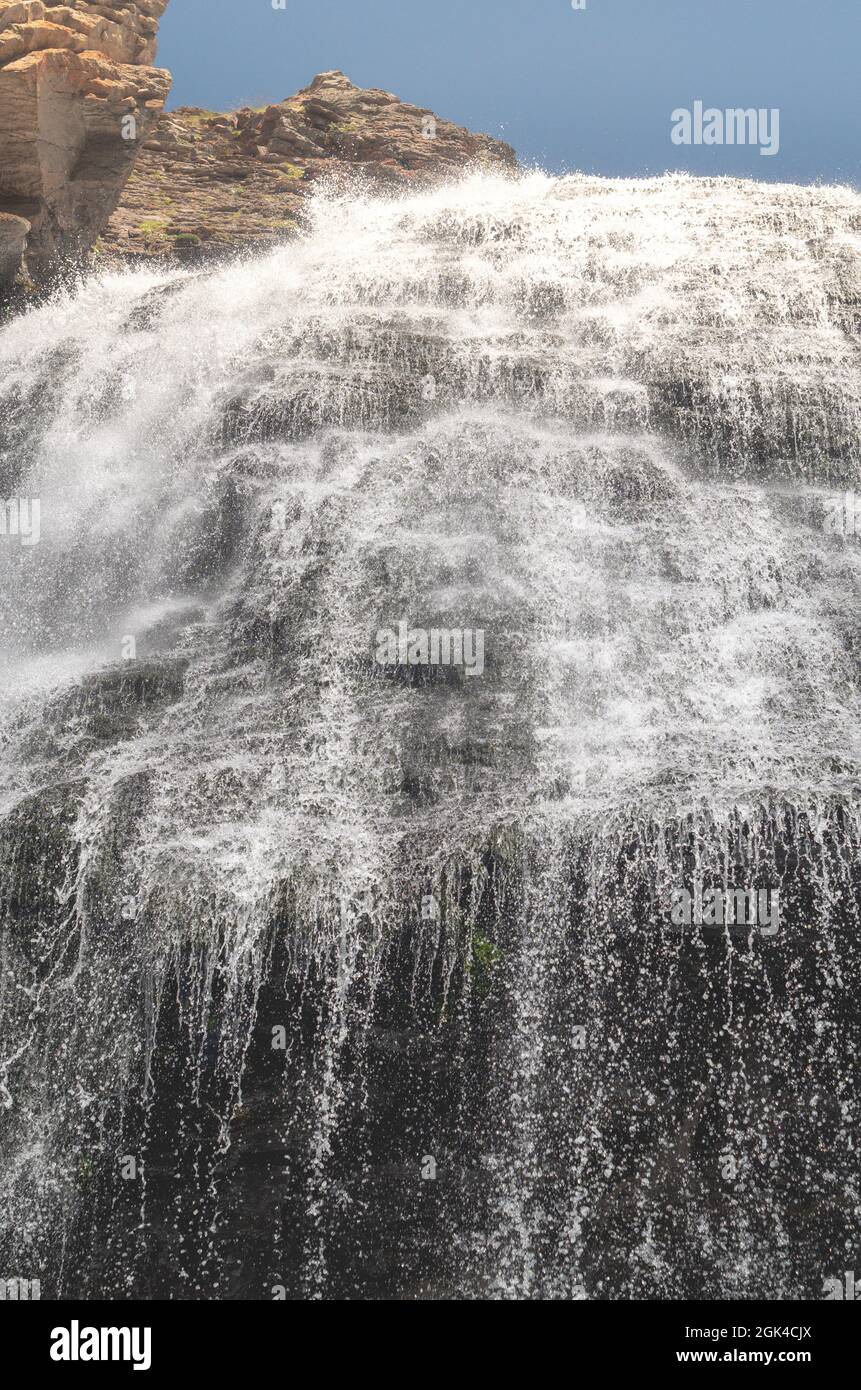 A beautiful waterfall in the mountains. Fresh water flows down from the ...