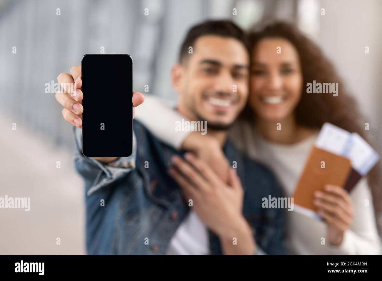 Happy Arab Couple Showing Smartphone With Blank Black Screen In Airport ...