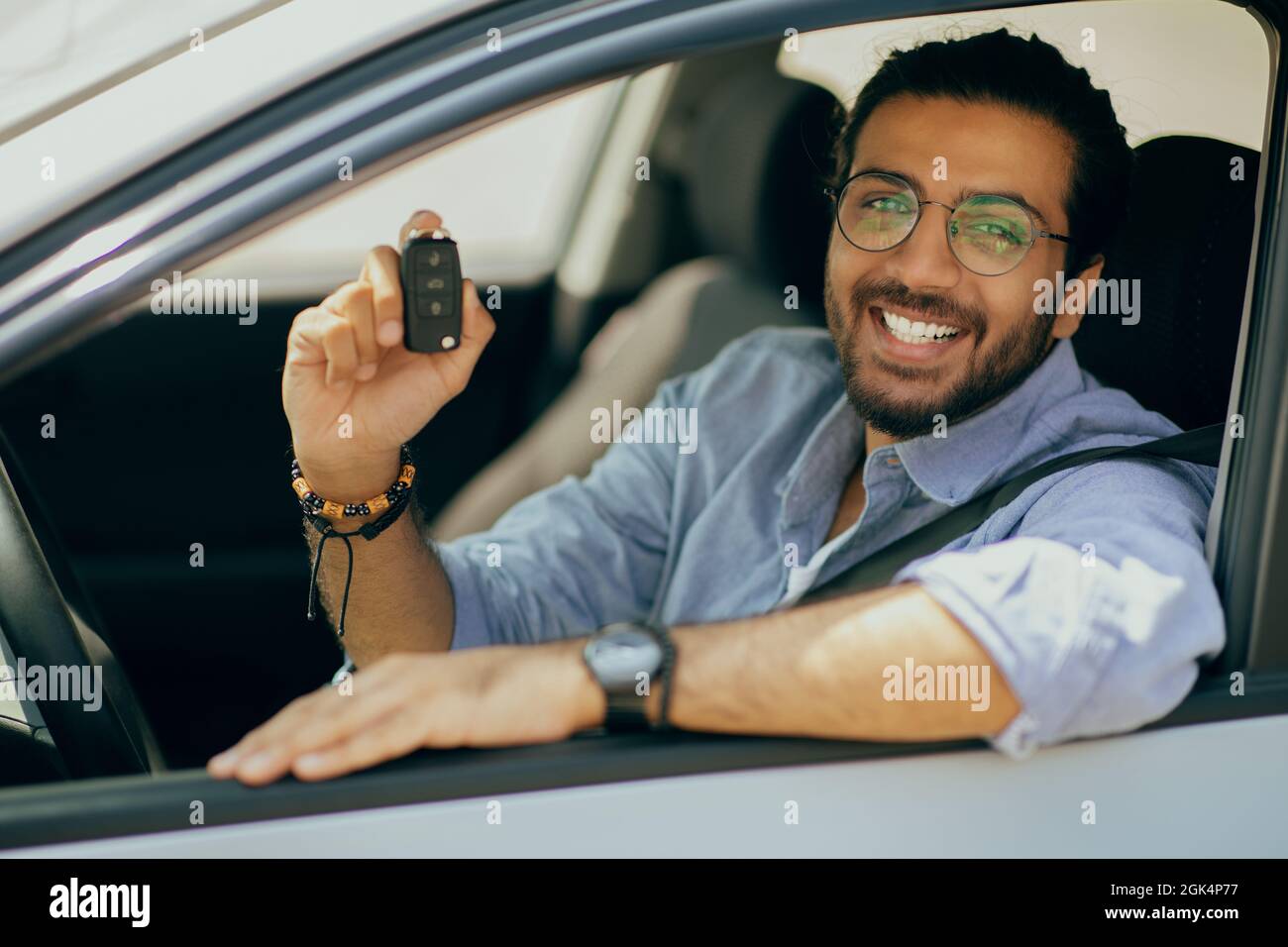 Cheerful middle-eastern long-haired guy showing car key Stock Photo