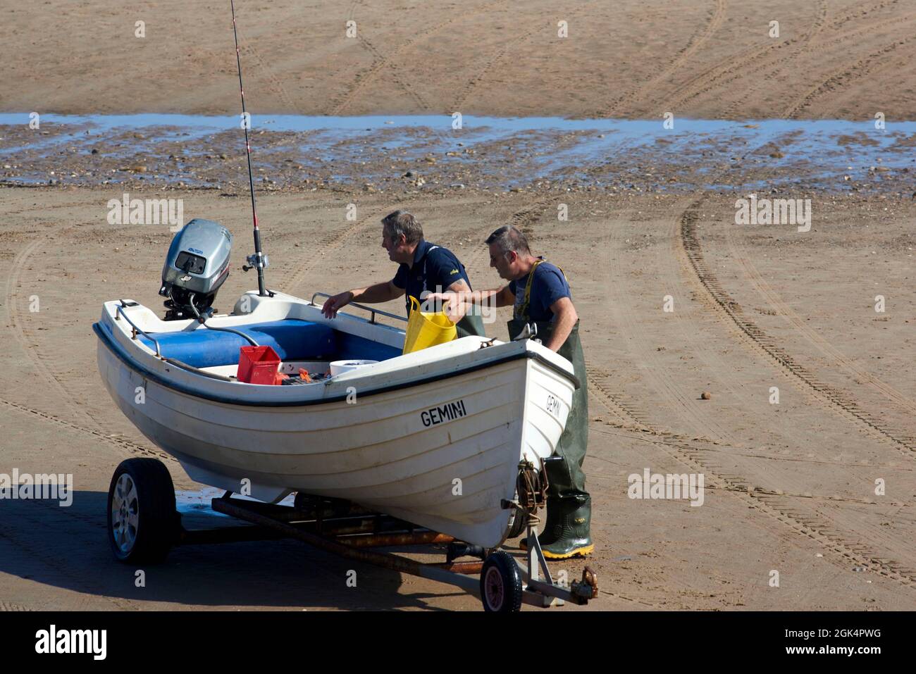 Fishing boats at Filey Beach, North Yorkshire east coast, busy with holiday makers, Northern England, UK Stock Photo