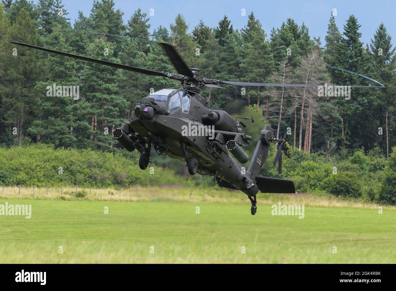 U.S. Soldiers, assigned to 1st Combat Aviation Brigade, 1st Infantry Division, come in for a landing at a forward arming and refueling point in a AH-64D Apache Longbow attack helicopter prior to aerial gunnery training at the 7th Army Training Command's Grafenwoehr Training Area, Germany, Aug. 4, 2021. Stock Photo