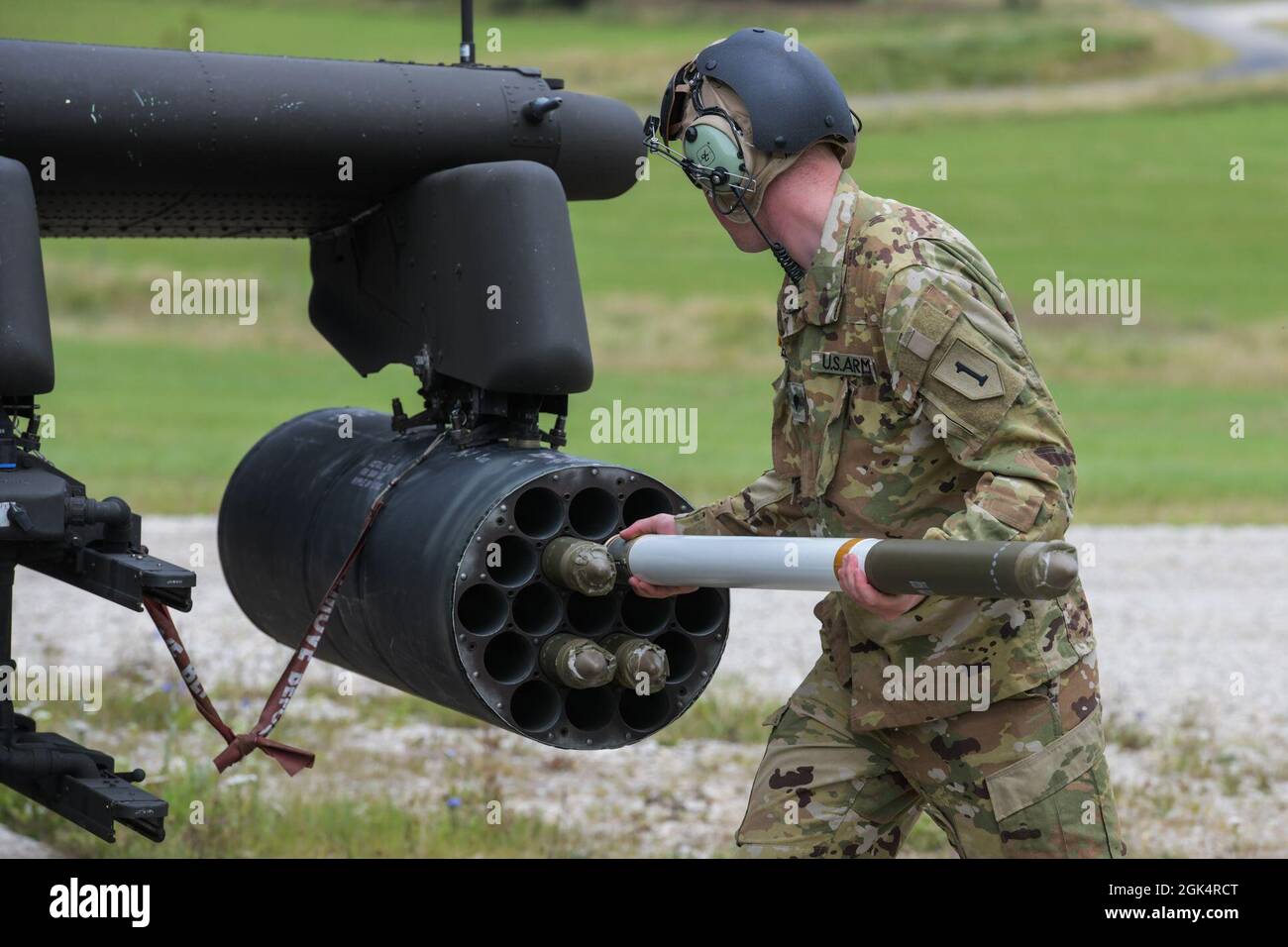 U.S. Army Spc. Robby Anderson, assigned to 1st Combat Aviation Brigade, 1st Infantry Division, inserts a rocket into the launcher of a AH-64D Apache Longbow attack helicopter prior to aerial gunnery training at the 7th Army Training Command's Grafenwoehr Training Area, Germany, Aug. 4, 2021. Stock Photo