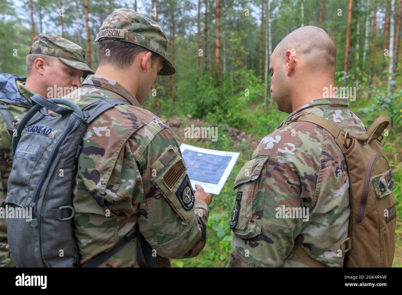 A team representing the United States of America, consults their map on the orienteering course during the Interallied Confederation of Reserve Officers military competition in Lahti, Finland on August 1st. Teams were given several different maps and tasked with find control points in the woods. The CIOR MILCOMP is an annual competition among NATO and Partnership for Peace nations. This competition test reserve service members from allied nations on several core disciplines in teams of three. Stock Photo