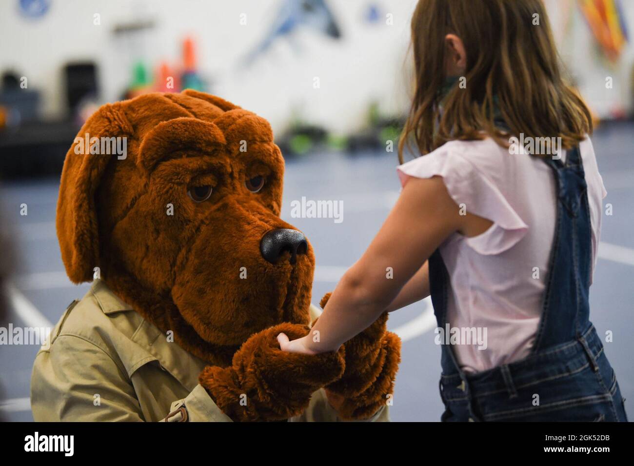 A child from the Moody Air Force Base Youth Center holds hands with McGruff the Crime Dog after an education day with Lowndes County Sheriff’s Office, 23rd Security Forces Squadron and 23rd Civil Engineer Squadron Fire Department at Moody Air Force Base, Georgia, Aug. 3, 2021. LCSO had the children recite McGruff’s catch phrase, “Take a bite out of crime!” Stock Photo