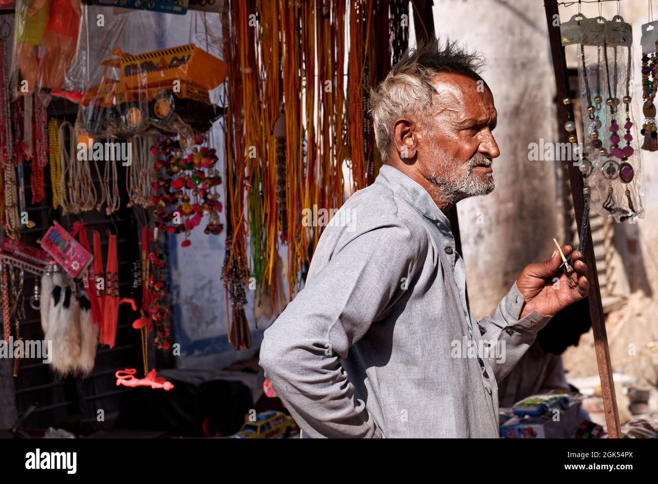 Orchha, Madhya Pradesh, India - March 2019: An elderly Indian man standing outside a shop and smoking a bidi cigarette. Stock Photo