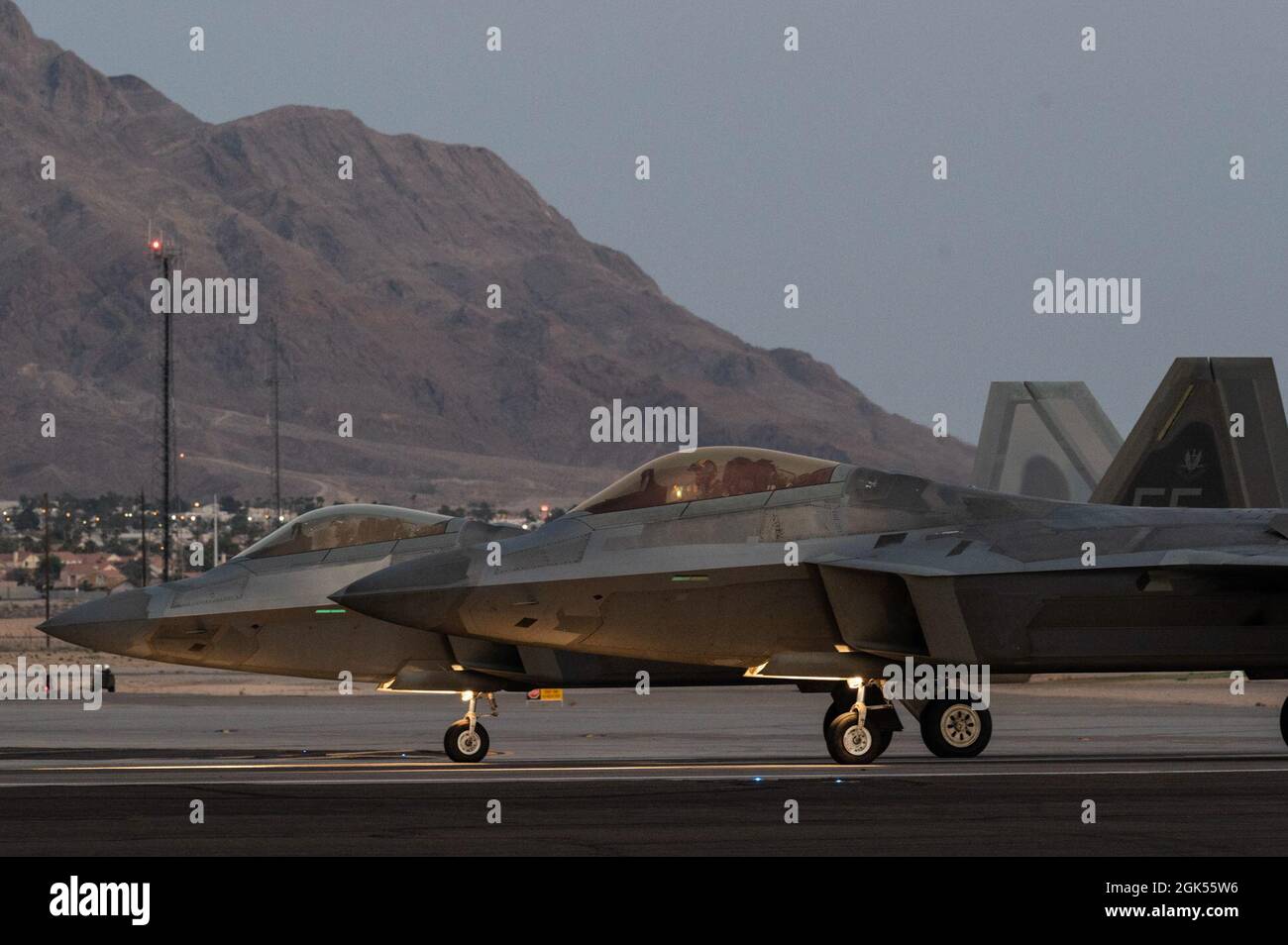 Two F-22 Raptors assigned to the 1st Fighter Wing, Langley Air Force Base, Virginia, line up prior to take-off for a night-training mission during Red Flag-Nellis 21-3 at Nellis Air Force Base, Nevada, Aug. 4, 2021. The 1st FW hosted RF-Nellis 21-3 as the lead wing with nearly 100 aircraft, such as the F-35, F-35, F-22, F-16CJ, F-16C, EC-130H, EA-18G, B-52, B-2, F/A-18 C/D, MQ-9, E-3, E-8, RC-135, RQ-4B30, RQ-4B40, U-2, HH-60, HC-130, KC-135 and KC-46, that participated in complex-mission scenarios against aggressor forces. Stock Photo