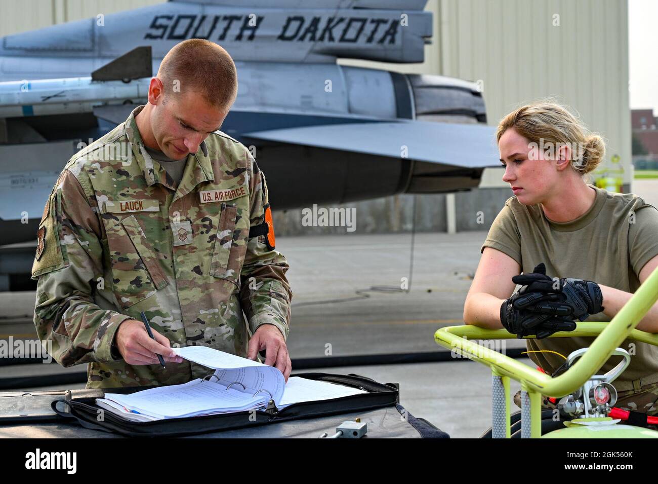 Master Sgt. Andrew Lauck and Staff Sgt. Mikayla Wilson, 114th Fighter Wing crew chiefs, review maintenance checklists prior to daily training during the 2021 Readiness Exercise at Joe Foss Field, Aug. 5. This exercise prepares Airmen for future threats through experience in realistic combat scenarios and is vital to ensure we are prepared for current and future contingencies. Stock Photo