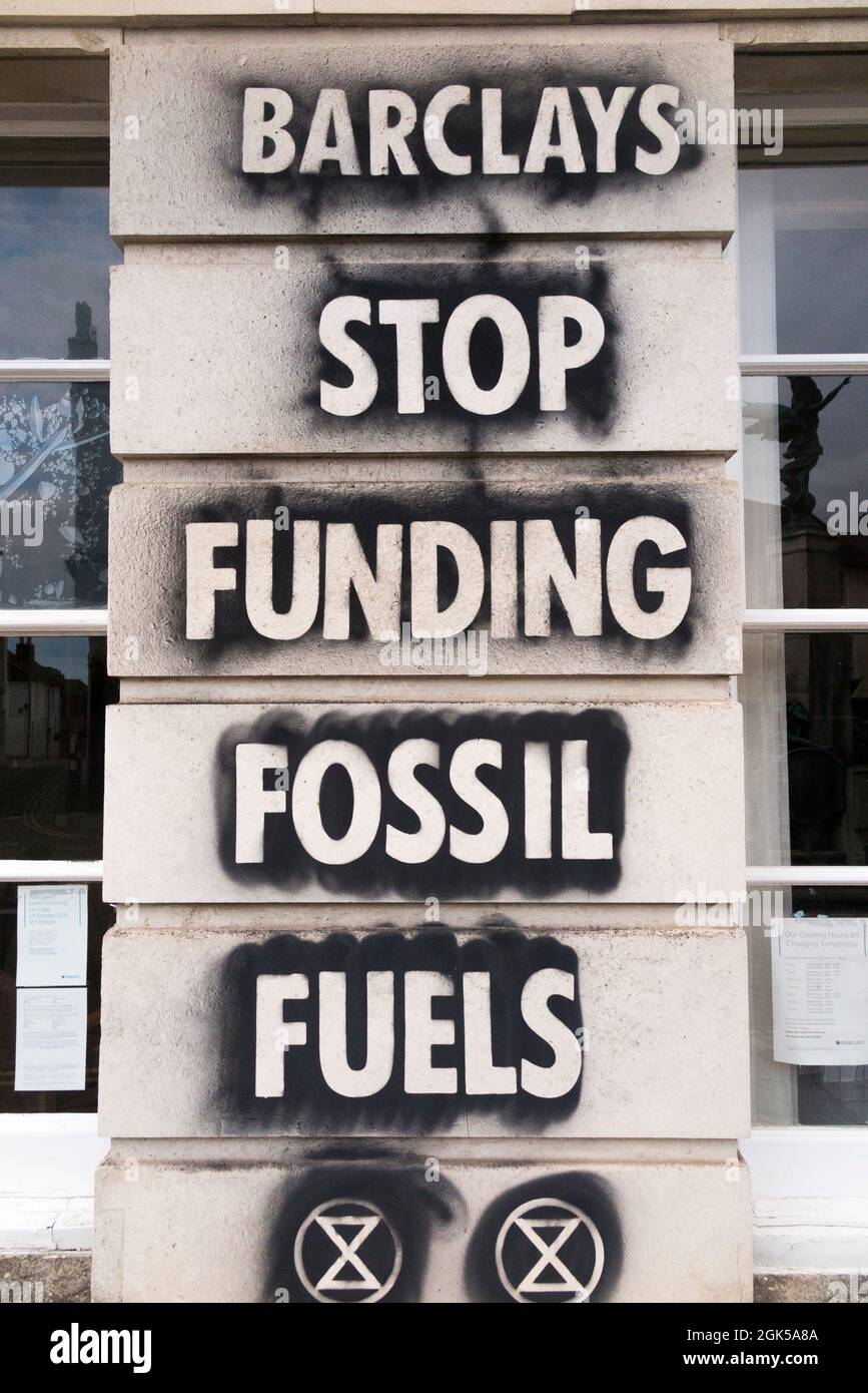Graffiti including the extinction rebellion logo, written on a Barclays Bank wall, protesting about the use of fossil fuel is which cause global warming and climate change. Lewes in East Sussex, UK. (127) Stock Photo