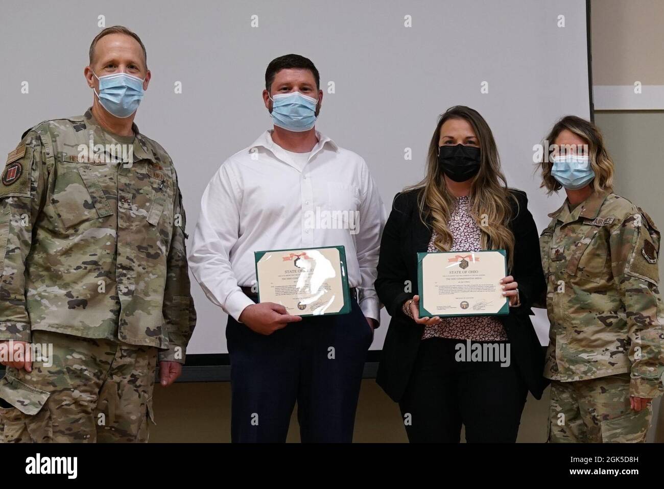 Col. Gregg Hesterman (left), commander of the joint task force that has provided oversight of Ohio National Guard COVID-19 support missions, and Maj. Shelley Brackman (right), of the 121st Medical Group, stand for a photo with Ricky Hoover (second from left) of the Ohio Department of Health and Erin Farrell of The Ohio State University Wexner Medical Center Aug. 6, 2021, at the 147th Regiment (Regional Training Institute) on the Defense Supply Center Columbus campus in Columbus, Ohio. Hoover and Farrell were awarded Ohio Commendation Medals for their outstanding partnerships with the Ohio Nati Stock Photo
