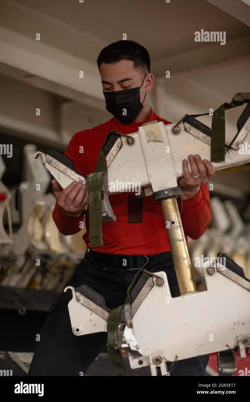 PACIFIC OCEAN (Aug. 6, 2021) Aviation Ordnanceman 3rd Class Darrin Kouhi, from San Diego, moves ordnance storage equipment aboard USS Abraham Lincoln (CVN 72). Abraham Lincoln is underway conducting routine operations in the U.S. 3rd Fleet area of operations. Stock Photo
