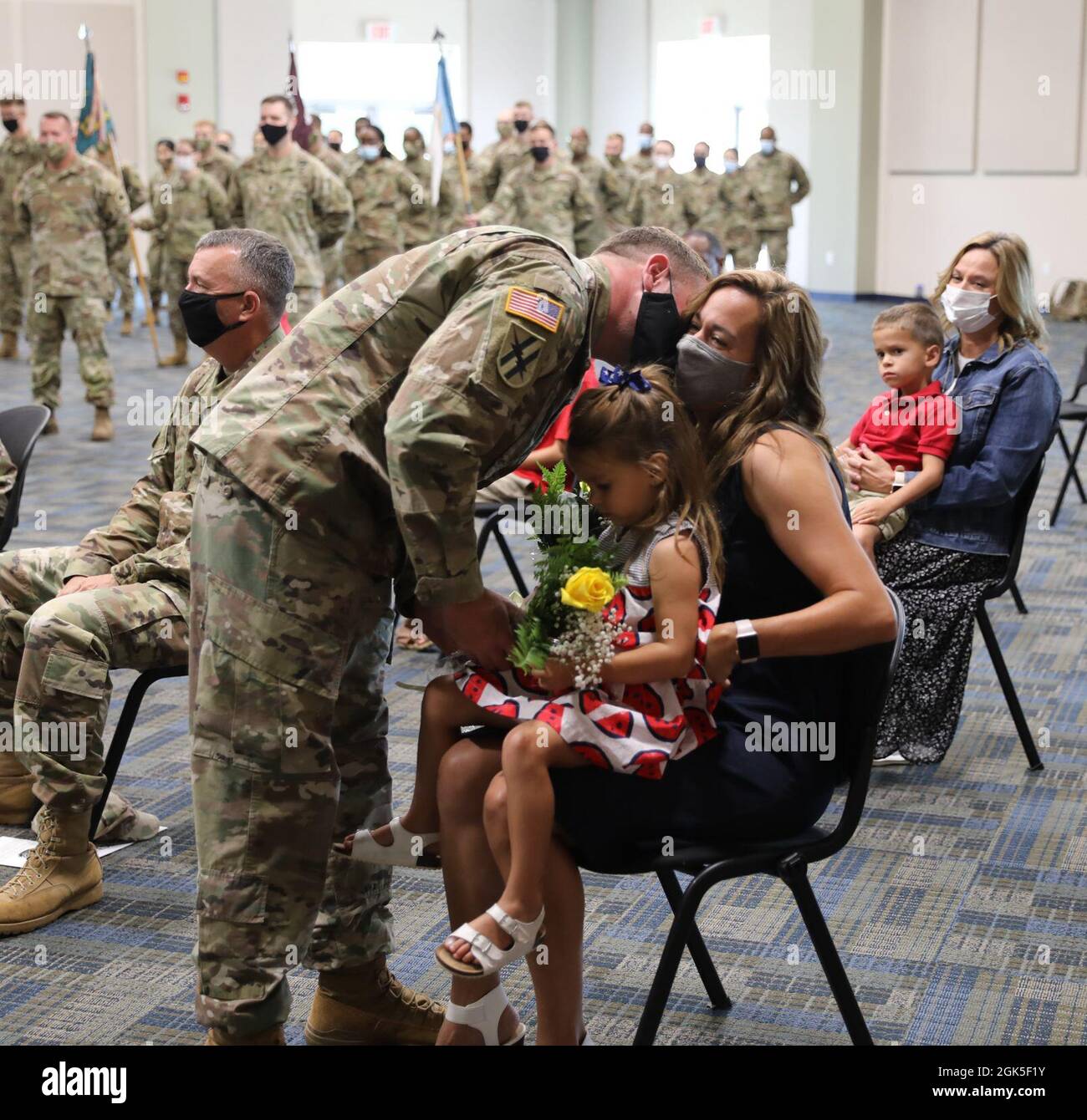 U.S. Army Major Aaron Holt, the incoming commander of the Marietta-based 781st Troop Command Battalion, presents bouquets of roses to his wife, Danielle, and daughter during a change of command ceremony at the Clay National Guard Center Marietta, Georgia, on August 7, 2021. Honored guests from around the state gathered both in-person and virtually to celebrate the service of Lt. Col. Pervis Brown. Stock Photo