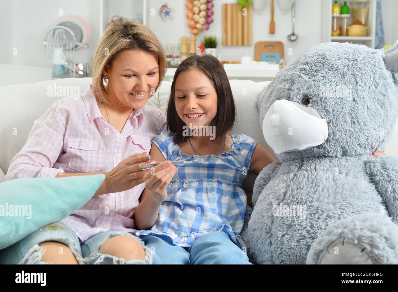 little girl and mother playing with toy teddy bear Stock Photo - Alamy