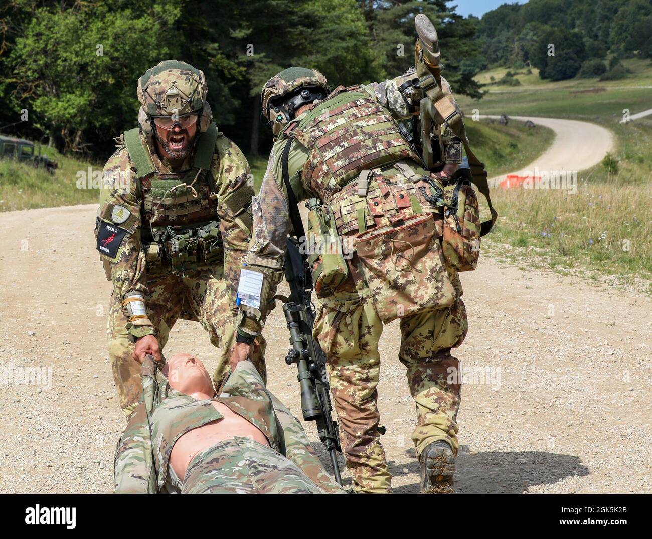 An Italian sniper team drags a simulated wounded Soldier during the Mogadishu event on Hohenfels Training Area Germany, Aug. 9, 2021. The 2021 European Best Sniper Team Competition is a U.S. Army Europe and Africa-directed, 7th Army Training Command hosted contest of skill that includes 14 participating NATO allies and partner nations at 7th ATC’s Hohenfels Training Area, Aug 8-14. Stock Photo