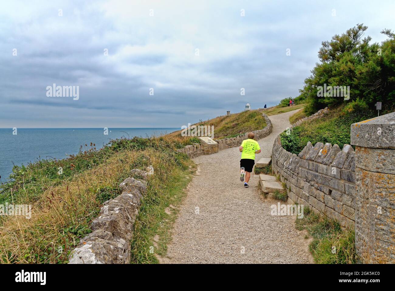 Male runner on the south west coastal path at Durlston Head on the Jurassic coast near Swanage Dorset England UK Stock Photo