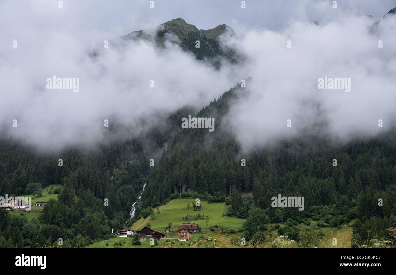 Steam clouds rise from the forest surrounding the small Egger waterfall in Antholz Obertal Stock Photo