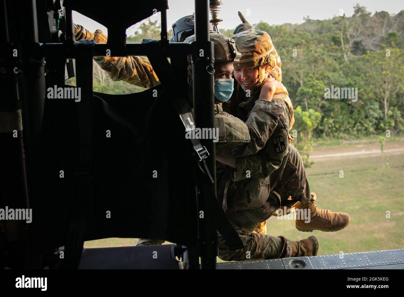 U.S. Army Combat Medics with Task Force Warrior, are pulled into an HH-60 Blackhawk on a Jungle Penetrator, a tool used to extract ambulatory casualties from heavily forested areas, during a hoist training at Baturaja Training Area, Indonesia, on August 9, 2021. Garuda Shield 21 is a two-week joint-exercise between the United States Army and Tentara Nasional Indonesia (TNI-AD Indonesia Armed Forces). The purpose of this joint-exercise is to enhance and enrich the jungle warfare ability of both the U.S. Army and Indonesian Army. Stock Photo