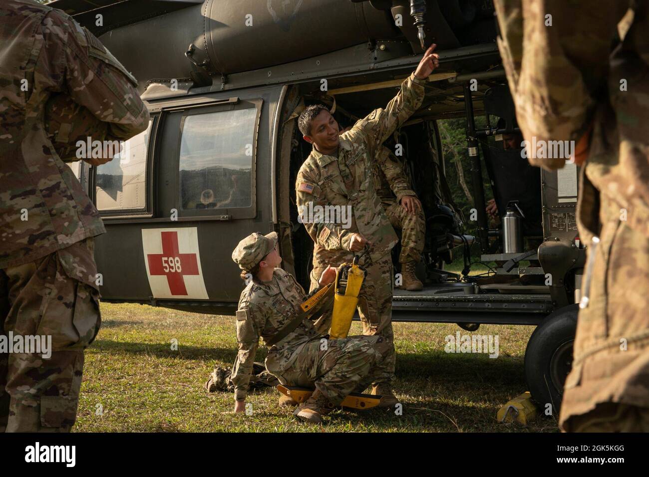 U.S. Army Staff Sgt. Rios, a Flight Paramedic with Task Force Diamond Head, 25th Aviation Regiment, gives instruction on how to operate a HH-60 Blackhawk hoist and how to operate a Jungle Penetrator, a tool used to extract ambulatory casualties from heavily forested areas, during training at Baturaja Training Area, Indonesia, on August 9, 2021. Garuda Shield 21 is a two-week joint-exercise between the United States Army and Tentara Nasional Indonesia (TNI-AD Indonesia Armed Forces). The purpose of this joint-exercise is to enhance and enrich the jungle warfare ability of both the U.S. Army and Stock Photo