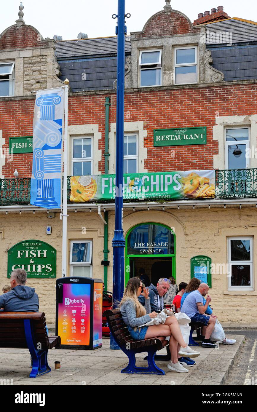 Holidaymakers enjoying fish and chips outside the Parade fish and chip restaurant in The Square, Swanage Dorset England UK Stock Photo