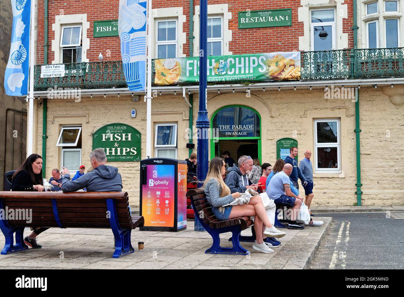 Holidaymakers enjoying fish and chips outside the Parade fish and chip restaurant in The Square, Swanage Dorset England UK Stock Photo