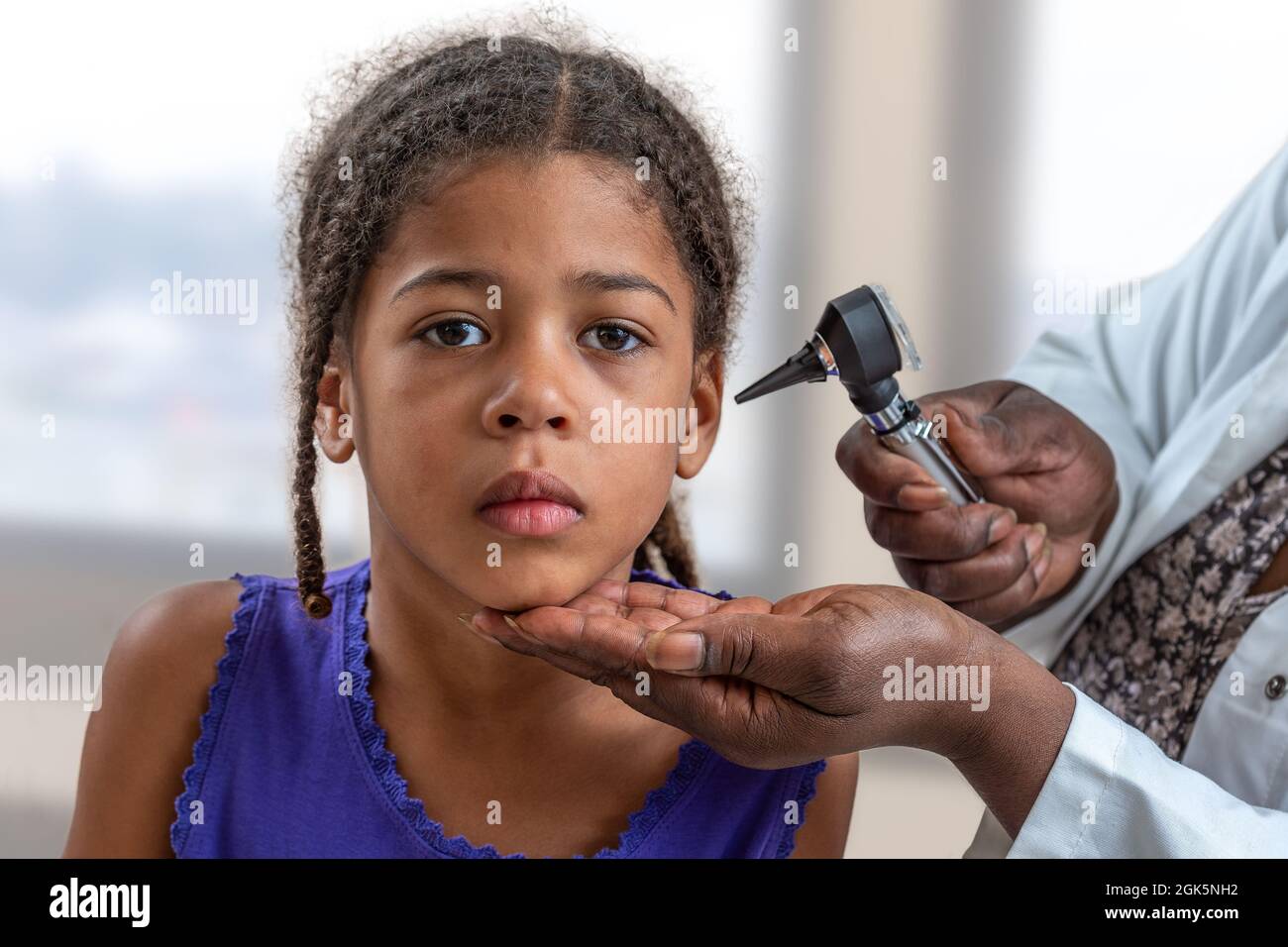 ENT physician looking into patient's ear with an instrument , Child