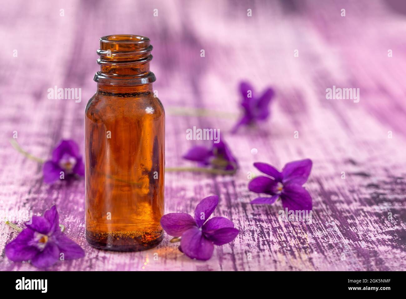 Oil and flower of violets for essential oil therapy Stock Photo