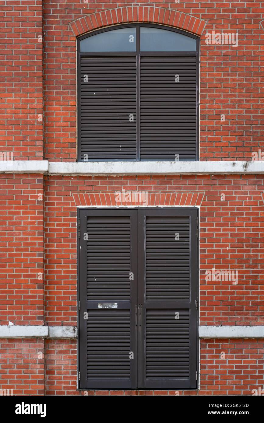 Red brick wall facade with metal windows Stock Photo