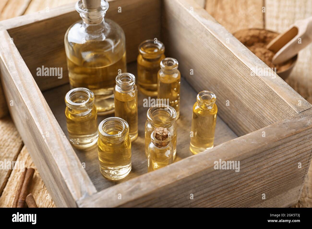 Bottles of cinnamon oil in box on wooden background Stock Photo