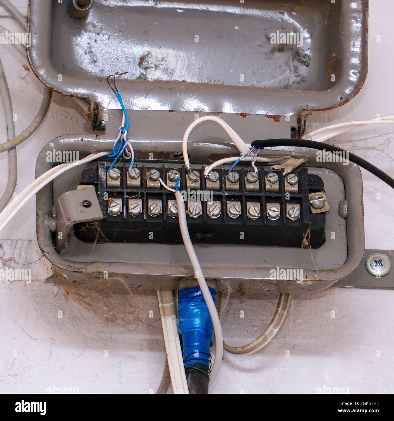 An old junction box with wires on a light wall. Soft Focus Stock Photo