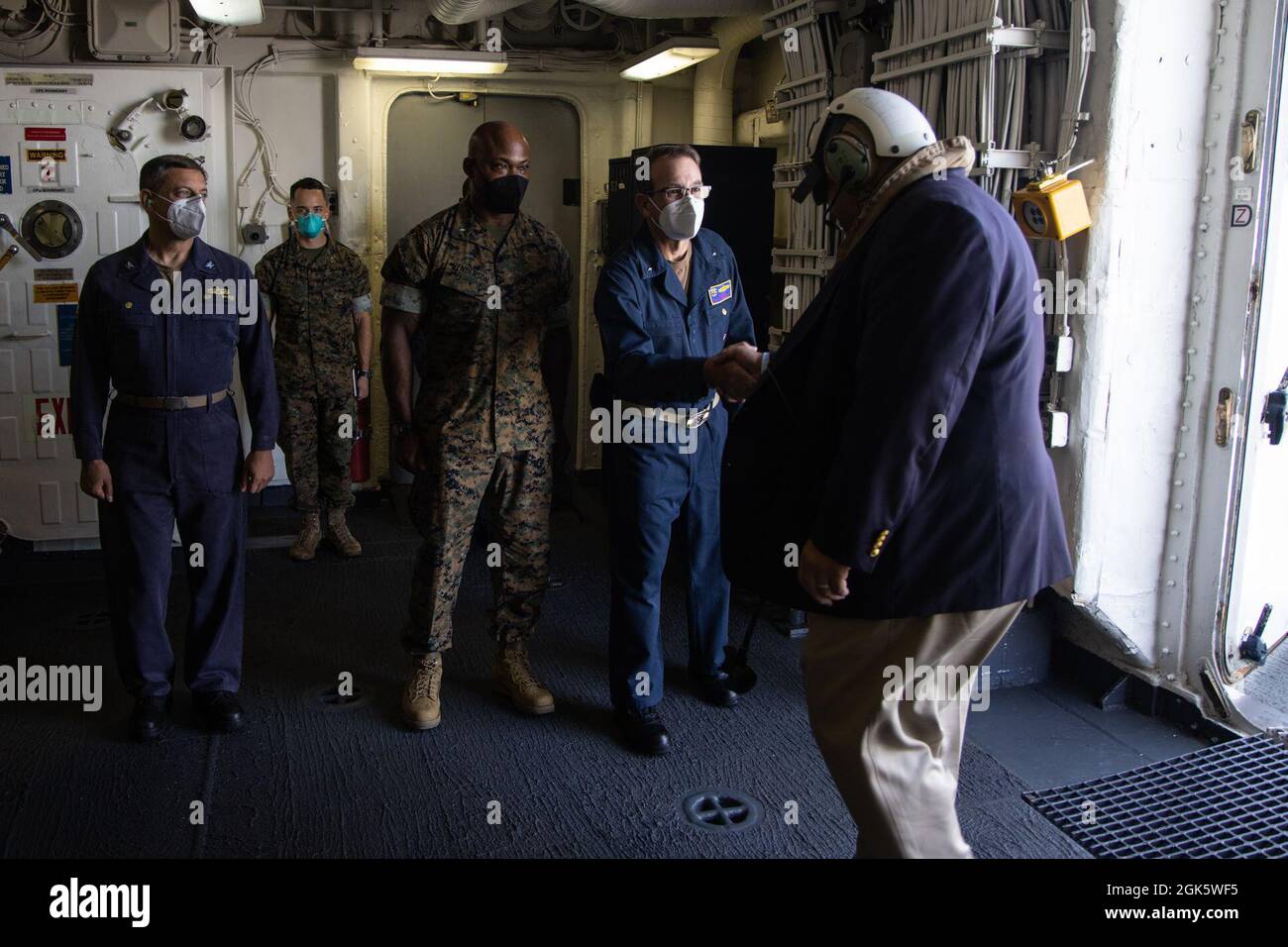 U.S. Secretary of the Navy Carlos Del Toro is greeted by Marine Corps and Navy leaders aboard the USS Kearsarge during Large Scale Exercise (LSE) 2021, off the coast of North Carolina, Aug. 10, 2021. II MEF is a maritime force inextricably linked to our Navy partners in U.S. 6th and 2nd Fleets, creating mutual interdependence with our Fleet counterparts leverages our collective capabilities and increases maritime lethality. LSE 2021 merges live and synthetic training capabilities to create an intense, robust training environment. Stock Photo