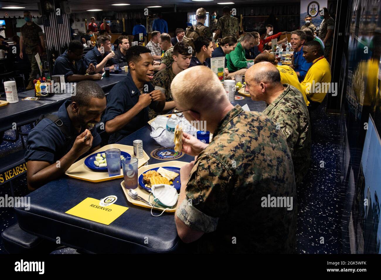U.S. Secretary of the Navy Carlos Del Toro, U.S. Representative Rob Wittman (R-VA), and U.S. Navy Adm. Michael Gilday, Chief of Naval Operations, have lunch with Marines and Sailors aboard the USS Kearsarge during Large Scale Exercise (LSE) 2021, off the coast of North Carolina, Aug. 10, 2021. II MEF is a maritime force inextricably linked to our Navy partners in U.S. 6th and 2nd Fleets, creating mutual interdependence with our Fleet counterparts leverages our collective capabilities and increases maritime lethality. LSE 2021 merges live and synthetic training capabilities to create an intense Stock Photo