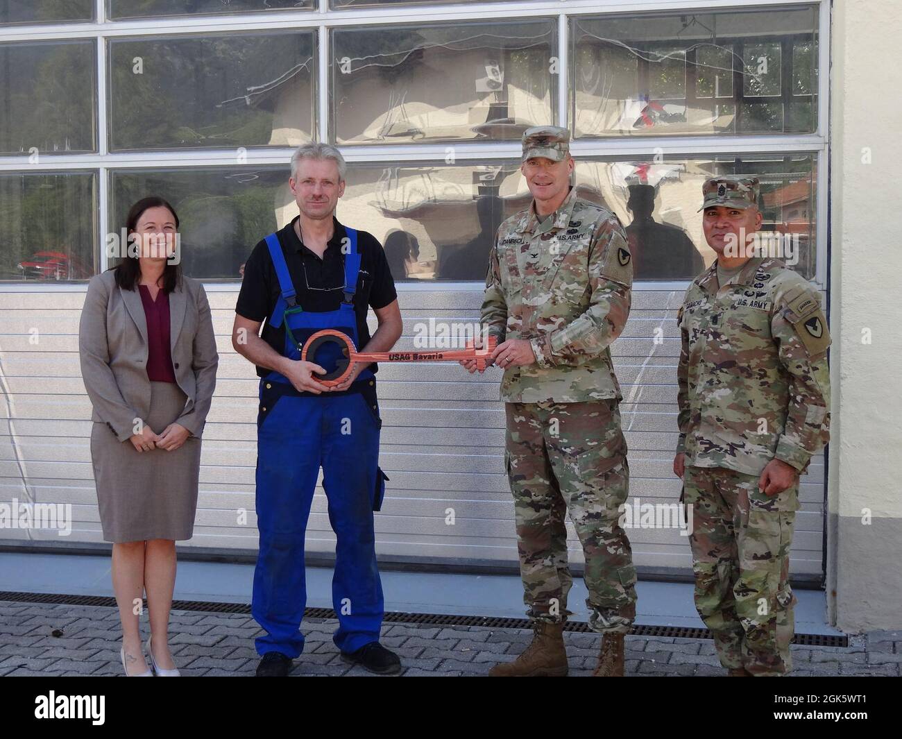 Garmisch Garrison Manager Laura Hemming, U.S. Army Garrison Bavaria Commander Col. Christopher Danbeck and Command Sgt. Maj. Sebastian Camacho turned over the symbolic facility key to Ernst Jacobi, 405th Army Field Support Brigade POV Inspector, Aug. 10, 2021. Stock Photo