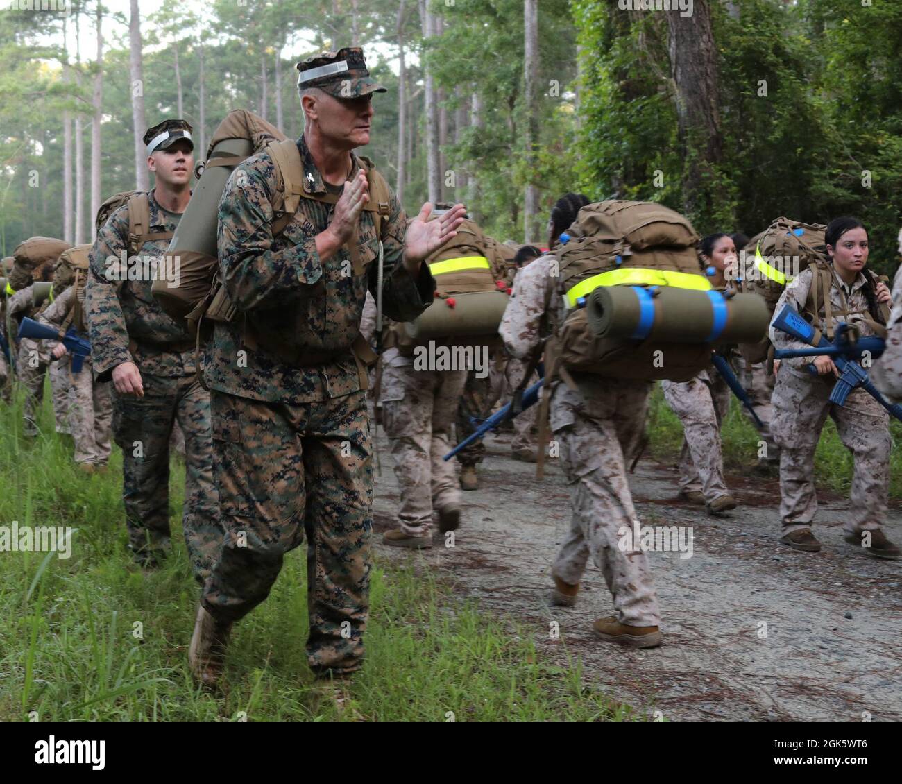 U.S. Navy Capt. Brian Tolbert encourages sailors attending Field Medical Training Battalion East (FMTB-E) during a four mile hike on Camp Johnson, N.C., Aug. 10, 2021. The sailors conduct increasingly difficult hikes during their training at FMTB-E to build endurance and skills that will be required when serving in Marine Corps units. Stock Photo
