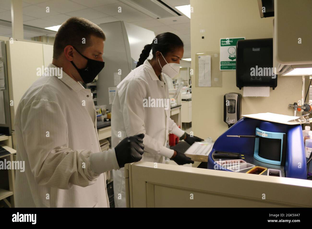 Two medical laboratory specialists, Spc. Eric Thompson (left) and Spc. Kershia Mukoro (right), identify different types of bacteria using the Automated Gram Stainer in the Evans Army Community Hospital Laboratory during their U.S. Army Reserve Annual Training with the 7450th Medical Operations Readiness Unit (MORU) Aug. 10, 2021. Stock Photo
