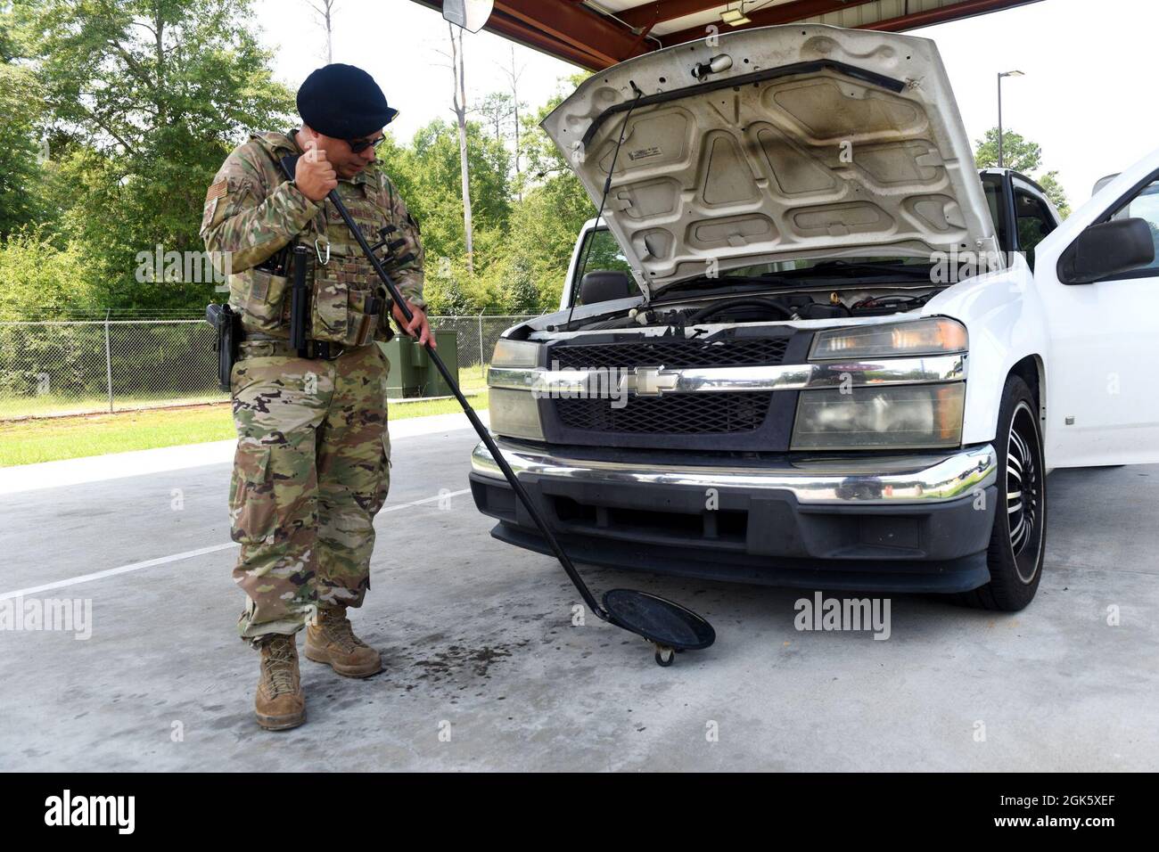 U.S. Air Force Staff Sgt. Daniel Martinez, 169th Security Forces Squadron non-commissioned officer in charge of the Visitor Control Center, inspects an oncoming vehicle for unauthorized substances and firearms at the front gate of McEntire Joint National Guard Base, South Carolina, Aug. 10, 2021. Stock Photo