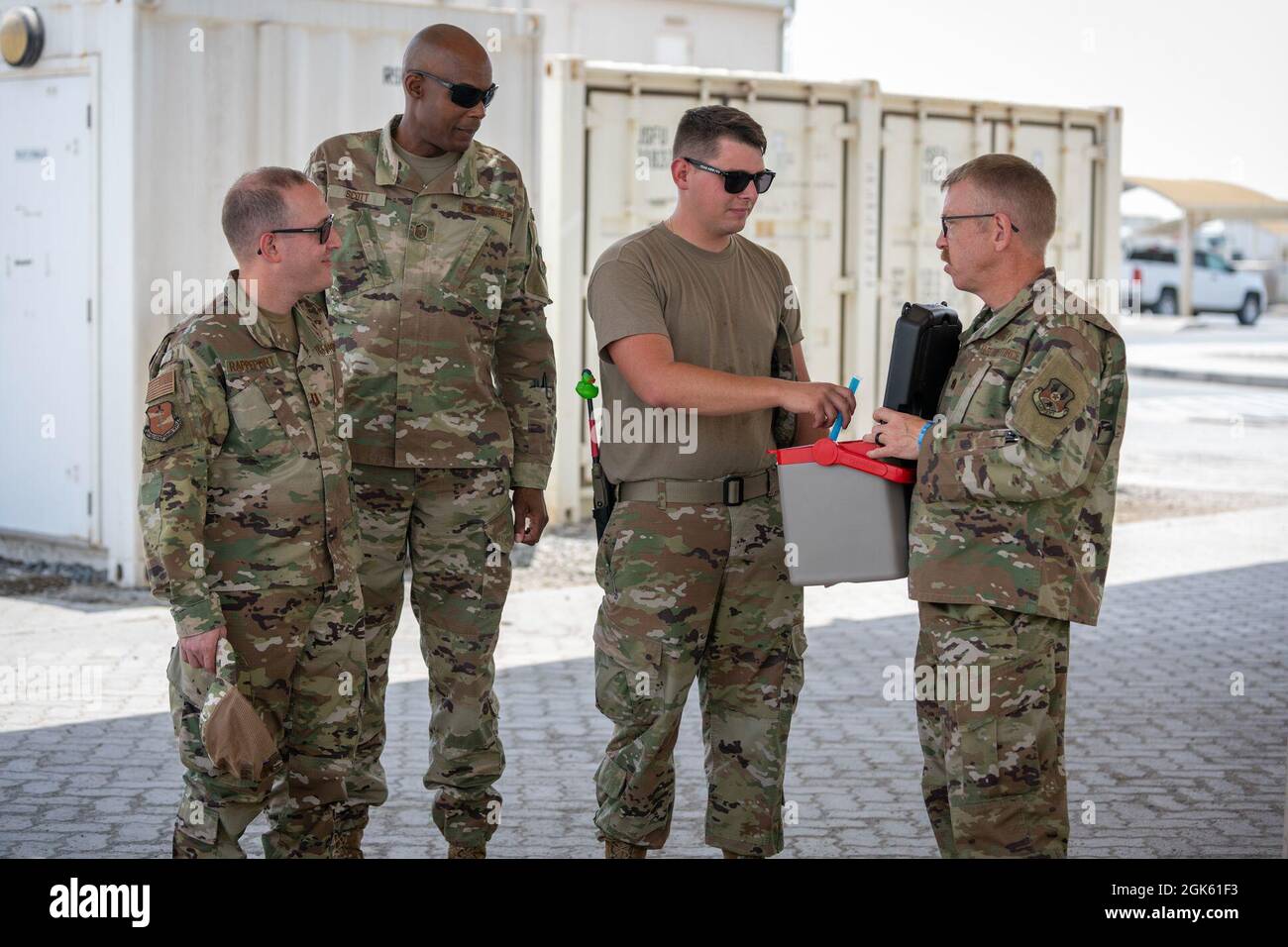 U.S. Air Force Chaplain Capt. Saul Rappeport (left), rabbi, 380th Air Expeditionary Wing, along with Master Sgt. Earl Scott (center-left), religious affairs airman, and Chaplain Maj. Thomas Duston (right), deputy wing chaplain, offer cold treats to members at Al Dhafra Air Base, United Arab Emirates, Aug 11, 2021. ADAB’s unique chapel team is comprised of three different religious leaders and offers Jewish, Catholic and Protestant services and events throughout the week. Stock Photo