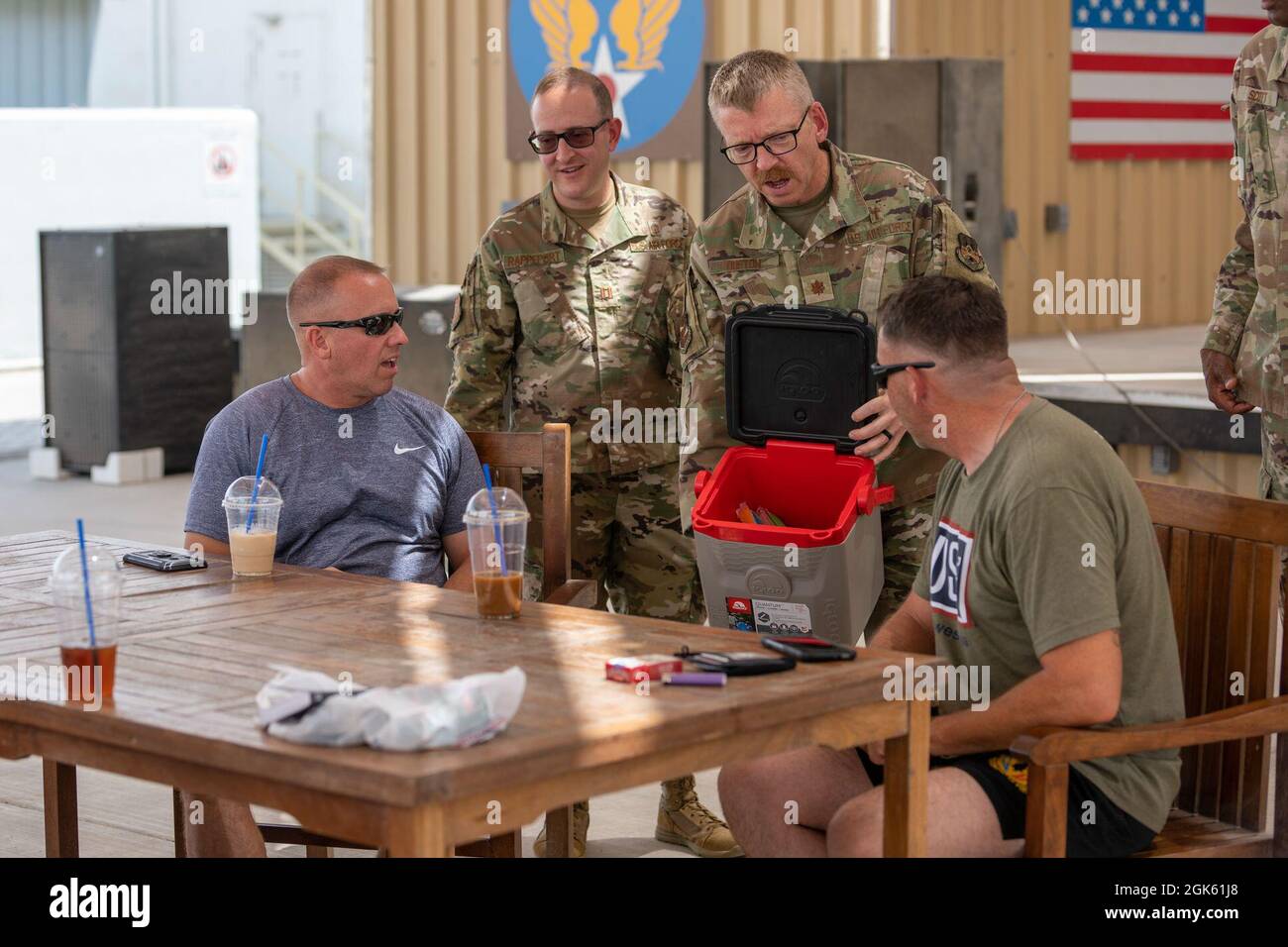 U.S. Air Force Chaplain Capt. Saul Rappeport (left-center), rabbi, 380th Air Expeditionary Wing, along with Chaplain Maj. Thomas Duston (right-center), deputy wing chaplain, offer cold treats to members at Al Dhafra Air Base, United Arab Emirates, Aug 11, 2021. ADAB’s unique chapel team is comprised of three different religious leaders and offers Jewish, Catholic and Protestant services and events throughout the week. Stock Photo