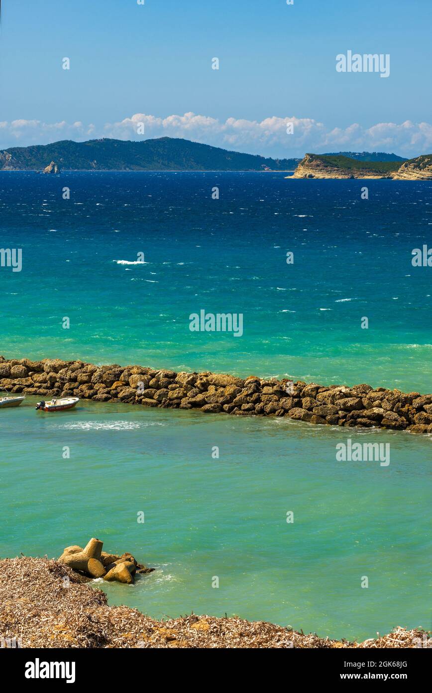 Picture postcard images of Agios Stefanos in Corfu incorporating sunny seascape view containing sea beaches rocks tourists tourism travel and holidays Stock Photo