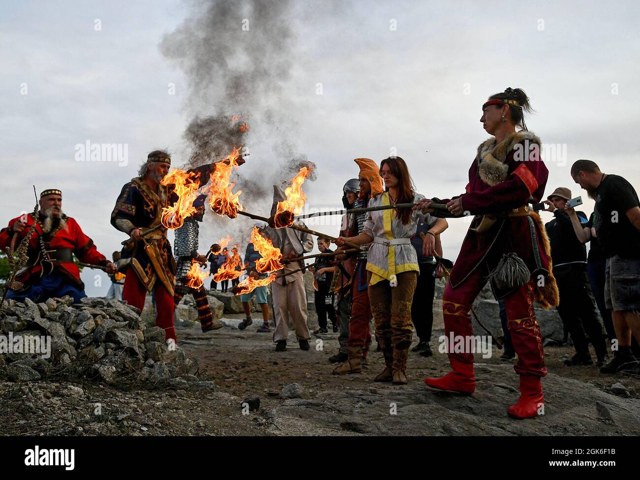 ZAPORIZHZHIA REGION, UKRAINE - SEPTEMBER 11, 2021 - History enthusiasts in period costumes hold burning torches during the Legends of Steppe 2021 Open Stock Photo