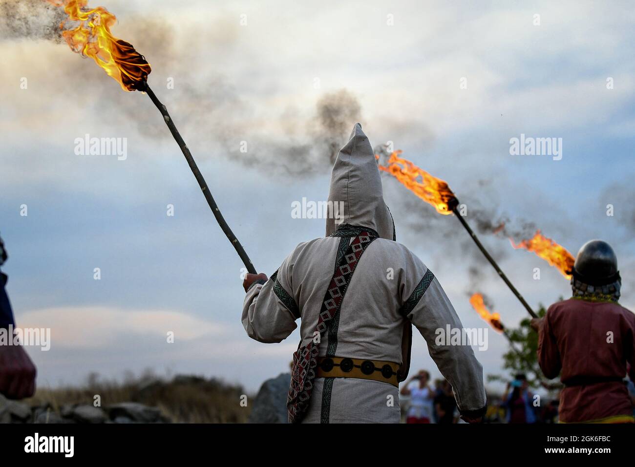 ZAPORIZHZHIA REGION, UKRAINE - SEPTEMBER 11, 2021 - History enthusiasts in period costumes carry burning torches during the Legends of Steppe 2021 Ope Stock Photo