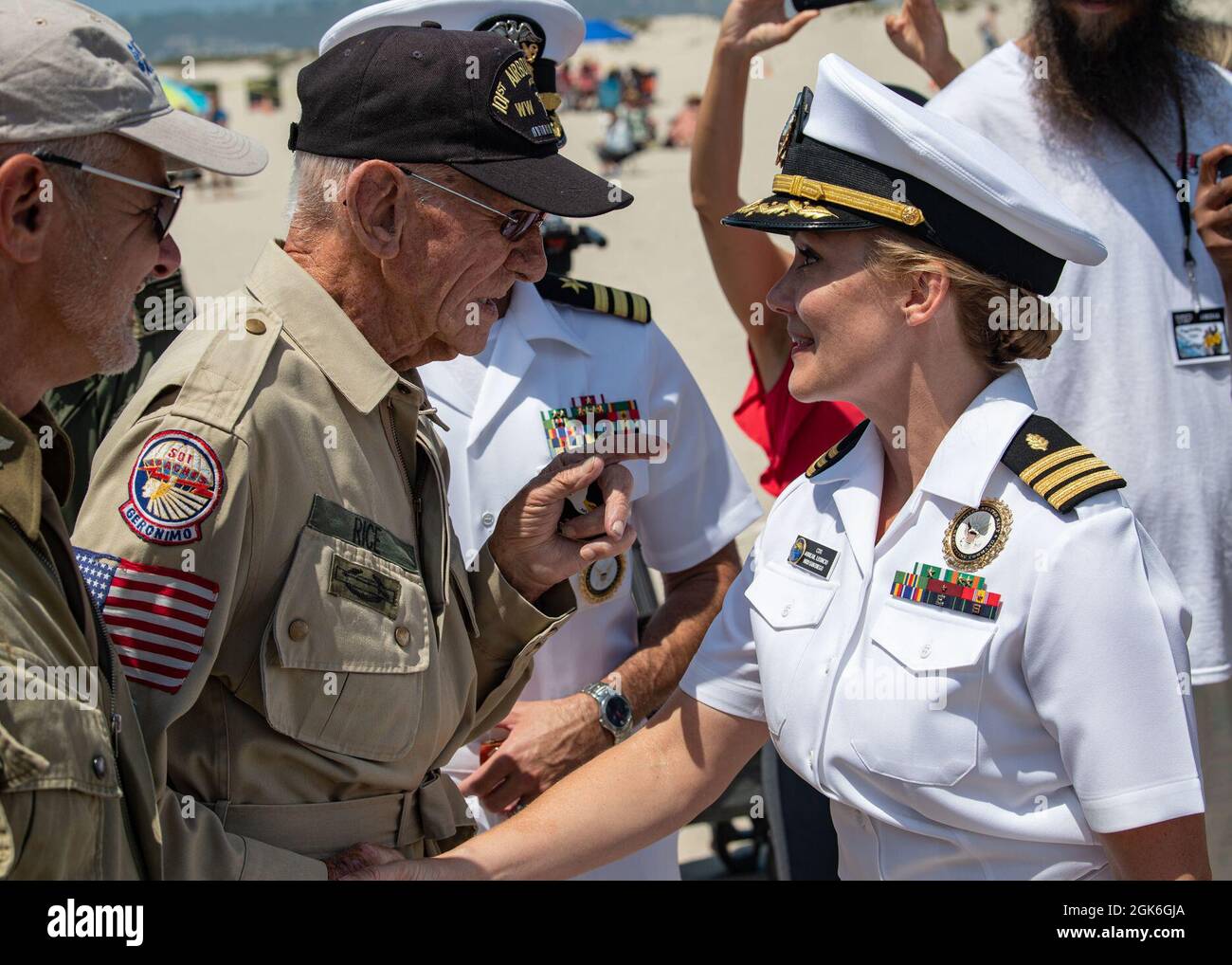 CORONADO, Calif. (Aug. 15, 2021) U.S. Army paratrooper and D-Day veteran, Tom Rice, from Coronado, California, of the 501st Parachute Infantry Regiment (PIR), 101st Airborne Division, C Company, shakes hands with U.S. Navy Nurse, Cmdr. Abreail D. Leoncio, senior medical officer recruiter assigned to Navy Talent Acquisition Group Southwest, during Rice’s 100th birthday celebration at historic Hotel del Coronado, Aug. 15, 2021. Rice was one of the thousands of men who jumped behind enemy lines into France on June 6, 1944, D-Day. Stock Photo