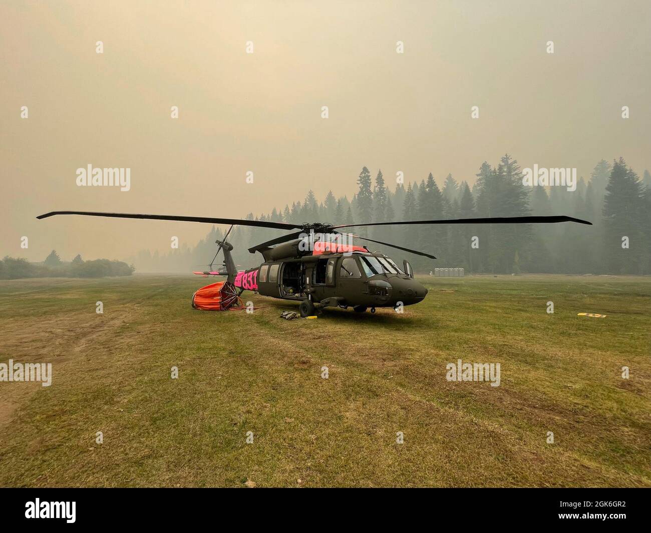 A U.S. Army UH-60 Black Hawk helicopter flown by the California Army National Guard is positioned at the Battle Creek helibase near Mineral, California, Aug. 17, 2021, while fighting the Dixie Fire. The fire eclipsed 600,000 acres and is currently the second-largest fire in California’s recorded history. Stock Photo