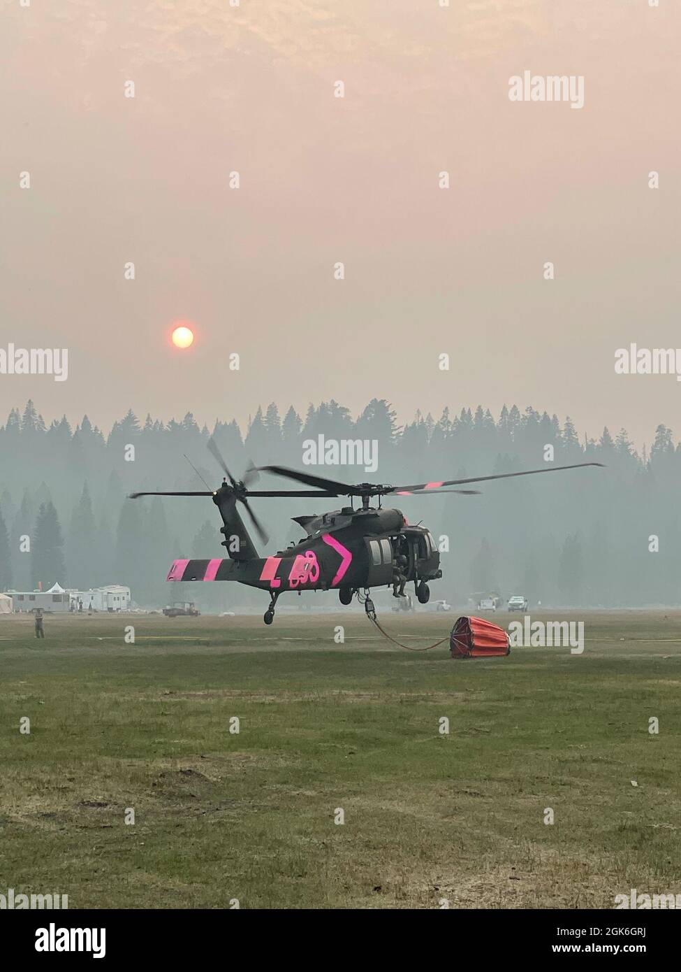 A U.S. Army UH-60 Black Hawk helicopter flown by the California Army National Guard lands at the Battle Creek helibase near Mineral, California, Aug. 17, 2021, while fighting the Dixie Fire. The fire eclipsed 600,000 acres and is currently the second-largest fire in California’s recorded history. Stock Photo