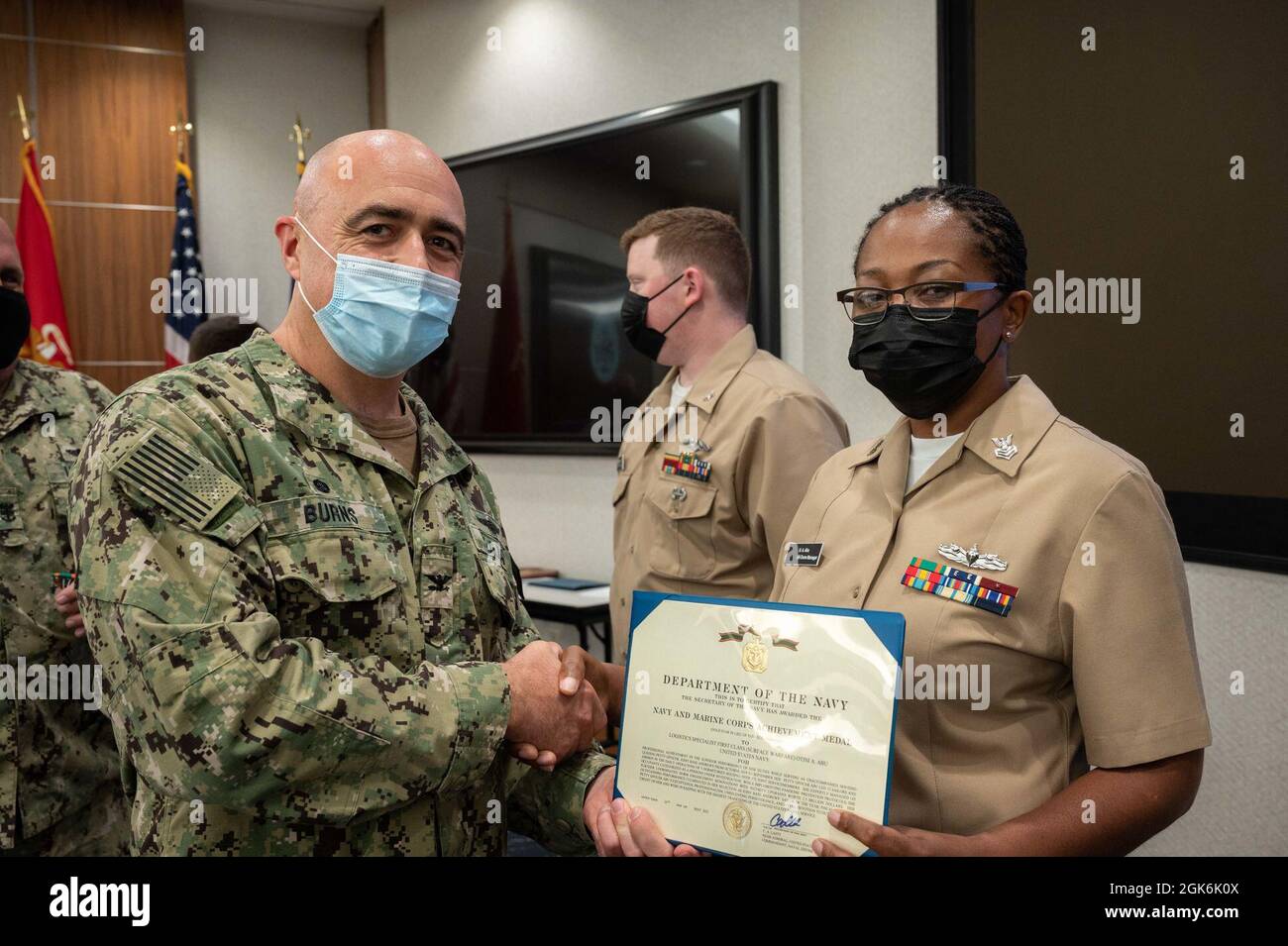 WASHINGTON, DC (Aug. 16, 2021) – Capt. Mark Burns (left), Naval Support Activity Washington commanding officer, presents Logistic Specialist 1st Class Otini Abu (right) with a Navy and Marine Corps achievement medal during an award ceremony held onboard Washington Navy Yard. Stock Photo