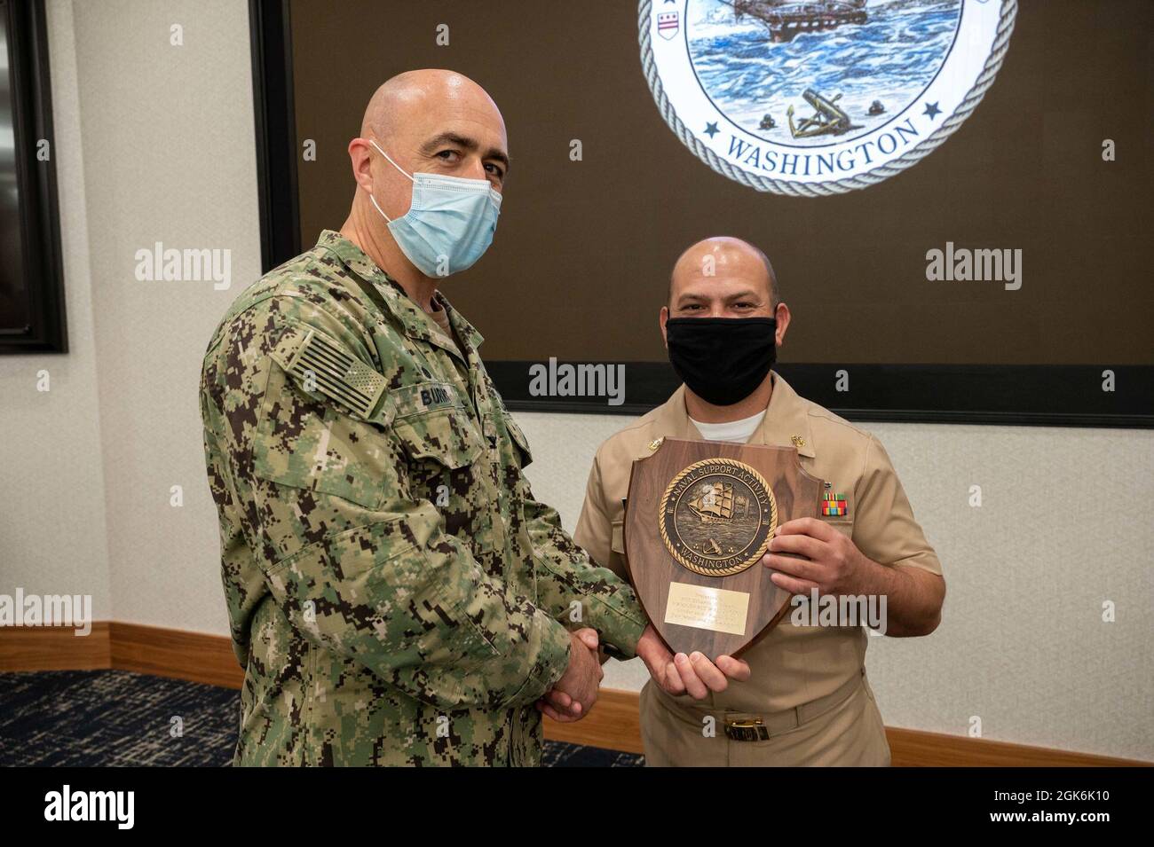 WASHINGTON, DC (Aug. 16, 2021) – Capt. Mark Burns (left), Naval Support Activity Washington commanding officer, presents Chief Navy Counselor Eduardo Rivera (right) with a commemorative plaque during an award ceremony held onboard Washington Navy Yard. Stock Photo